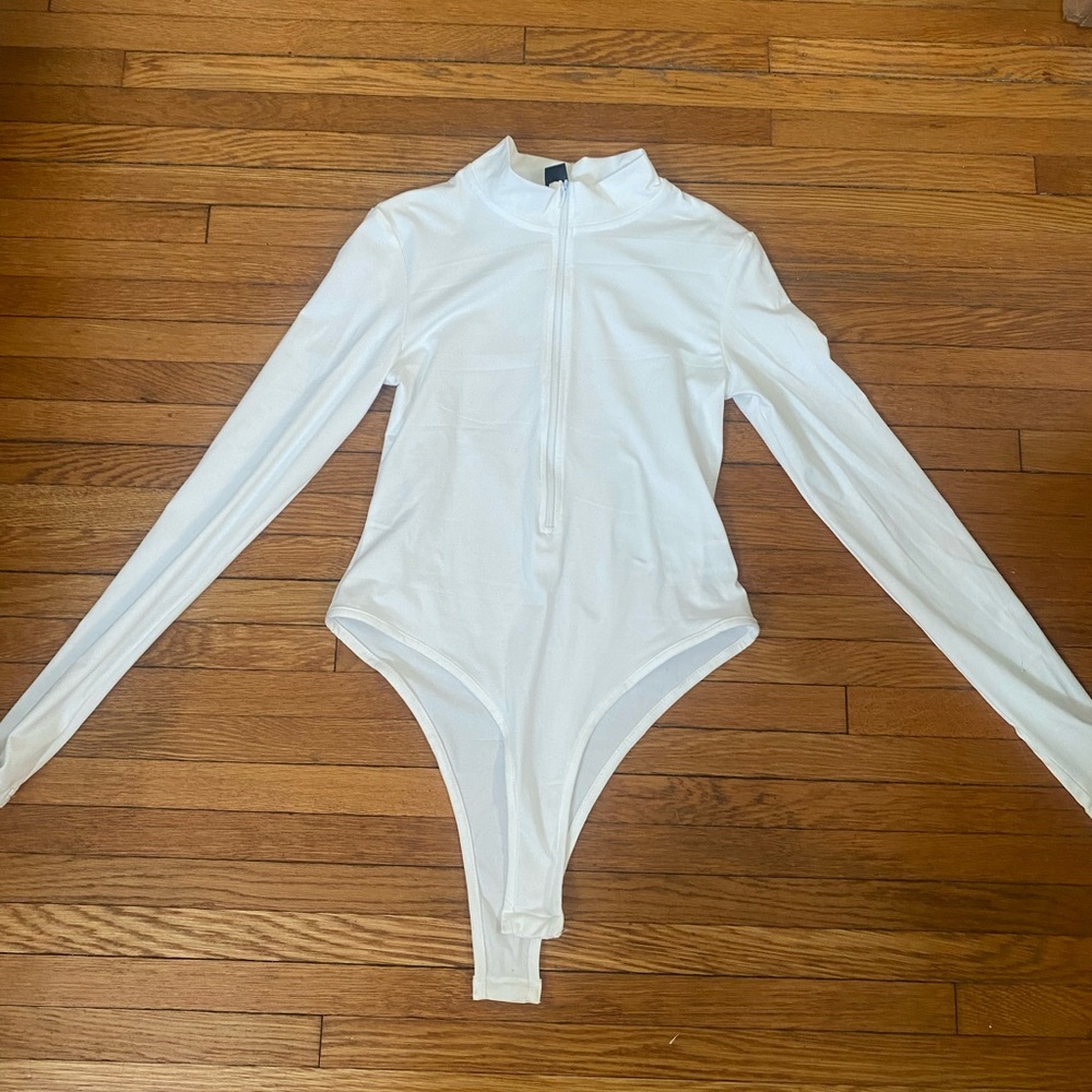 NEW, never worn. Women’s white athletic jacket with body suit buttons.